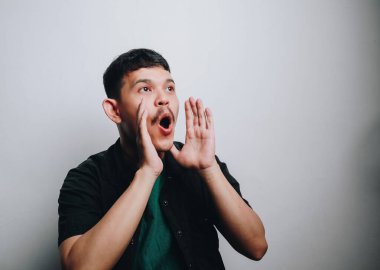 Basit bir fotoğrafta heyecanını ve şaşkınlığını ifade eden genç bir adam..