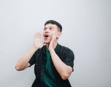 Genç bir adam, arka planda açık elle heyecan sergiliyor..