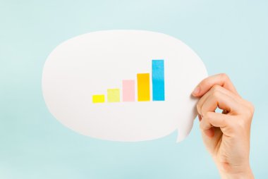 Büyüyen bir çubuk grafiği ile konuşma balonu tutan el. Ölçümleri, önlemler, analytics kavramı.