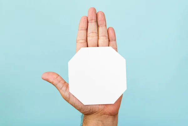 Stop hand and octagon shape on blue background — Stock Photo, Image