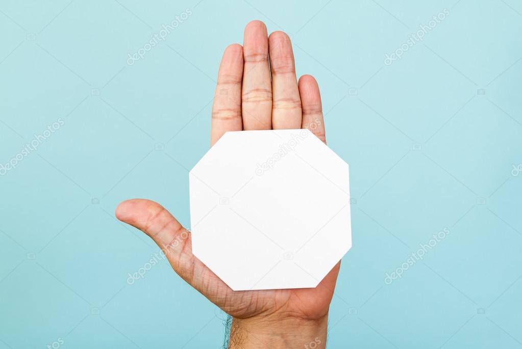 Stop hand and octagon shape on blue background