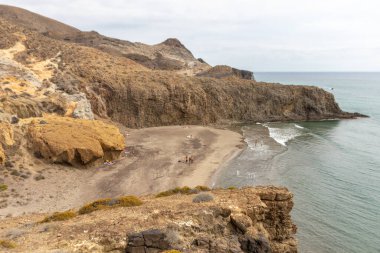 Almerya, İspanya. 10 Ekim 202. Günbatımında Endülüs 'teki Cabo de Gata Ulusal Parkı' ndaki Barronal plajında insanlar