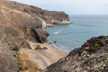 Almerya, İspanya. 10 Ekim 202. Günbatımında Endülüs 'teki Cabo de Gata Ulusal Parkı' ndaki Barronal plajında insanlar
