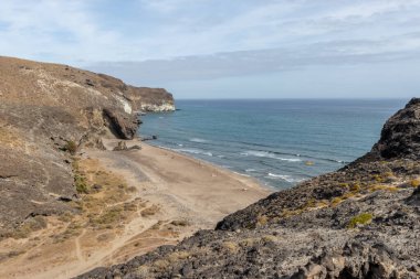 Almerya, İspanya. 10 Ekim 202. Günbatımında Endülüs 'teki Cabo de Gata Ulusal Parkı' ndaki Barronal plajında insanlar