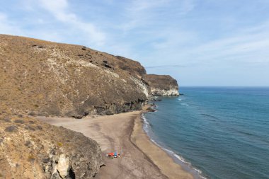 Almerya, İspanya. 10 Ekim 202. Günbatımında Endülüs 'teki Cabo de Gata Ulusal Parkı' ndaki Barronal plajında insanlar