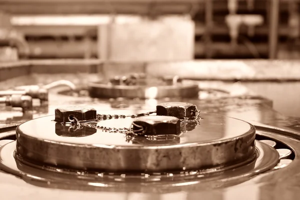 Close up of bolts safety wired together on a retaining plate for a bearing. sepia  tone. — Stock Photo, Image