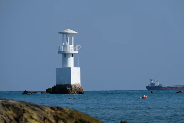 Mavi deniz güneşli bir deniz feneri.