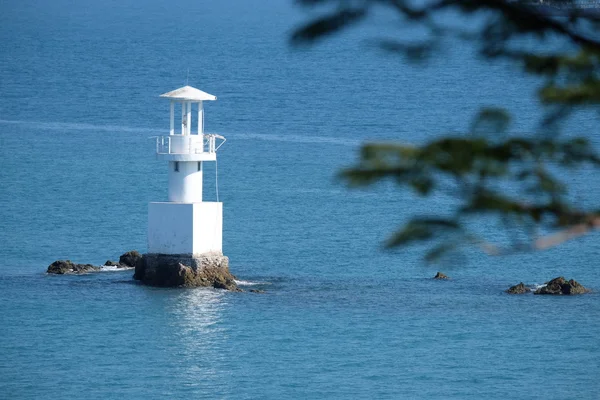 Faro in una giornata di sole con il mare blu . — Foto Stock