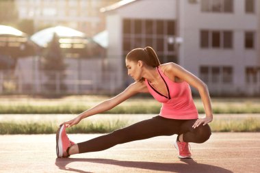 genç kız güneşli bir günde sokakta bir egzersiz yapıyor