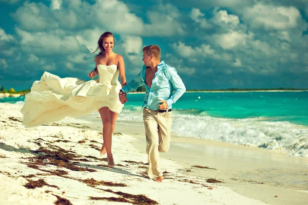 Frischvermählte laufen am Strand entlang — Stockfoto