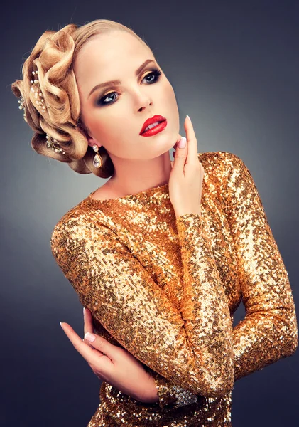 Blonde vrouw in een gouden jurk — Stockfoto
