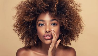Afro saçlı güzel Afrikalı Amerikalı bir kadın birine portre güzelini anlatıyor. Komik bir manken bir şey hakkında fısıldıyor. Etkileyici yüz ifadeleri.
