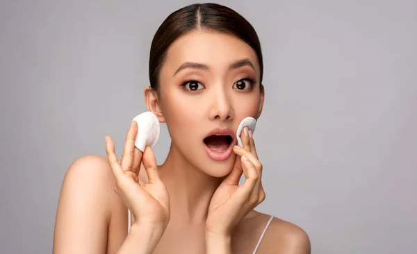 Beautiful Asian woman with Cotton pads. Beauty Chinese girl with clean and white skin.