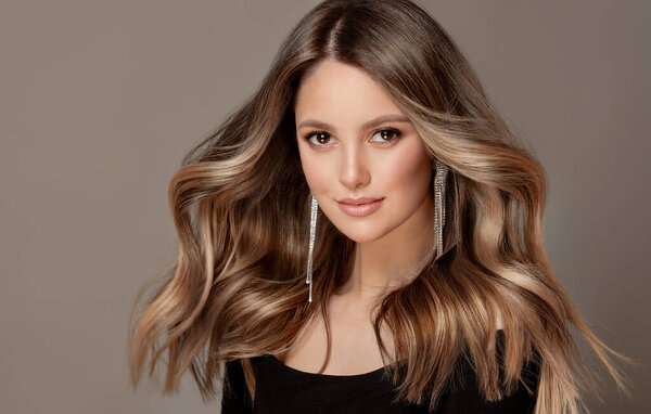 Beauty girl with long and shiny wavy Hair ,coloring and toning, shatush and balayash . Beautiful woman model with curly hairstyle .