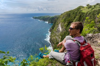 Uzun yürüyüşe çıkan kimse dağın oturan sırt çantası ile ve manzarasının tadını çıkarın