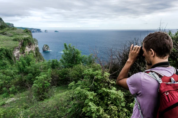 Jeune homme avec sac à dos sur la colline faisant une photo de paysage pittoresque — Photo