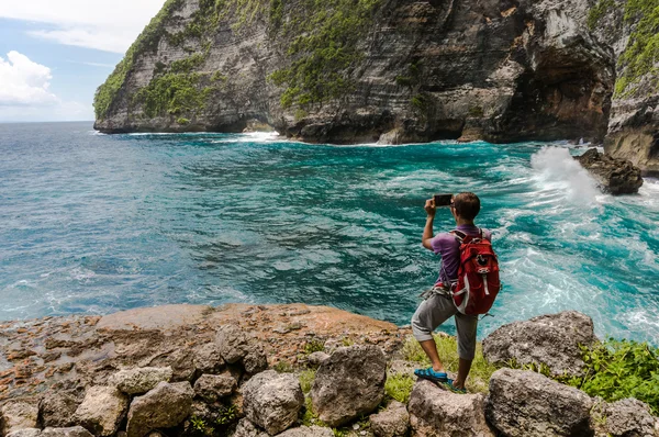 Joven haciendo una instantánea en su tableta. Está en la hermosa cala. — Foto de Stock