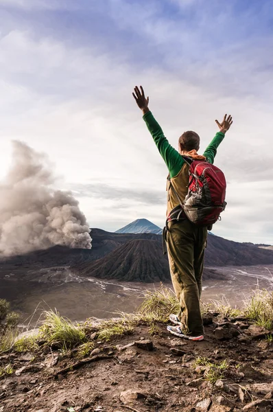 L'homme encouragé sur la colline regarde l'éruption du volcan Bromo — Photo