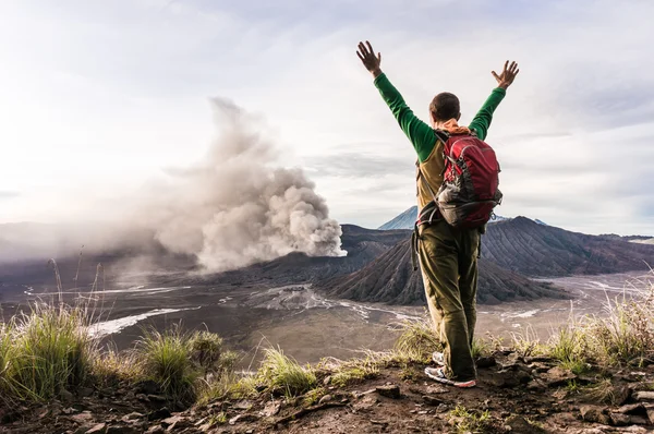 L'homme encouragé sur la colline regarde l'éruption du volcan Bromo — Photo
