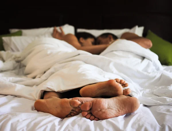 Прекрасная пара спит в постели, сосредоточена на ногах — стоковое фото