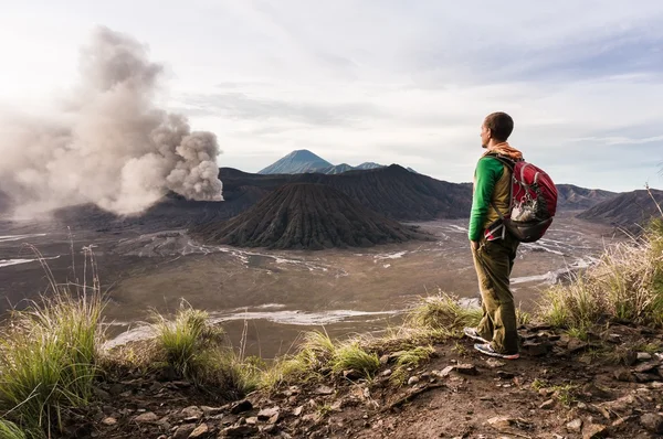 L'homme sur la colline regarde l'éruption du volcan Bromo Image En Vente