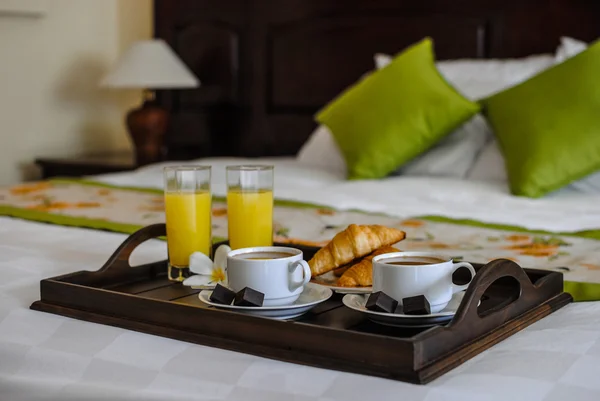 Petit déjeuner au lit pour un couple avec café et croissants sur une table Photo De Stock