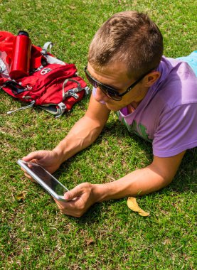 Çim döşeme ve onun tableti kullanarak adam