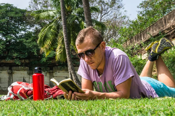 L'homme allongé sur l'herbe et lisant ses notes — Photo