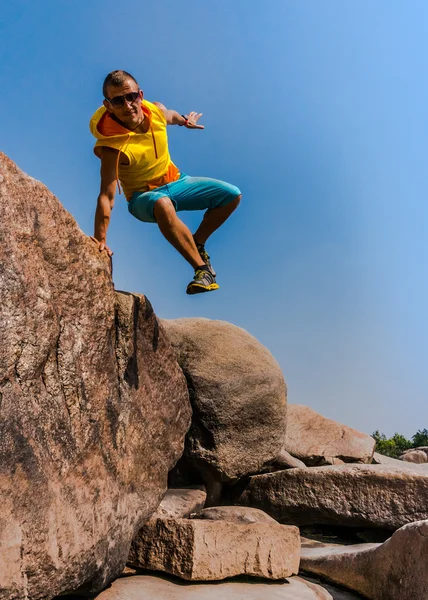 Junger Mann springt zwischen den Felsen — Stockfoto