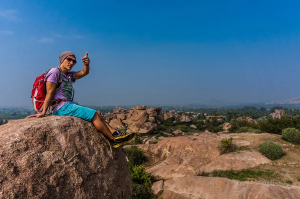 Joven sentado en la montaña, ordenando la vista después del trekking — Foto de Stock