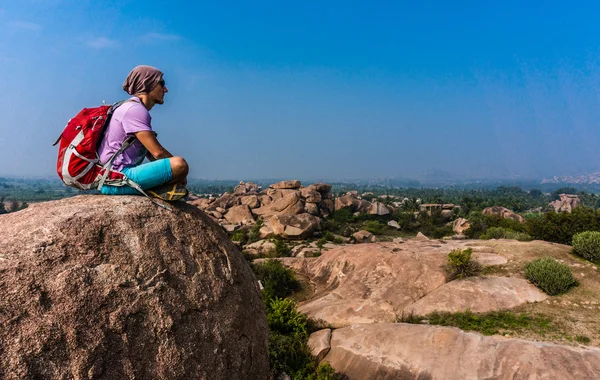 Mladý muž sedí na horu a do kraje po Treking — Stock fotografie