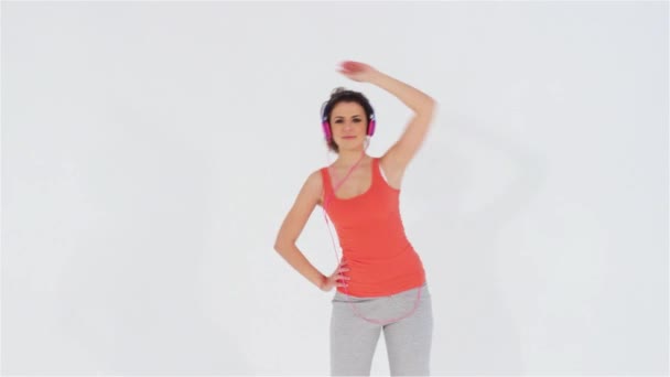 Chica deportiva con auriculares haciendo ejercicio — Vídeos de Stock