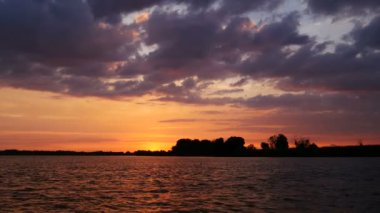 Renk günbatımı güneş ve turuncu bulutlar ile Nehri