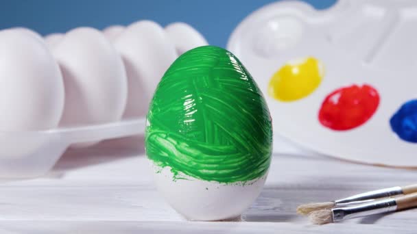 Живопис великодніх яєць з зеленою щіткою, підготовка до весняних свят, релігійне святкування, художнє барвисте уявлення — стокове відео