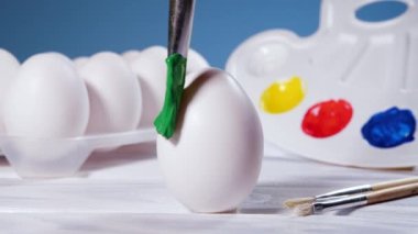 Yeşil fırçayla Paskalya Yumurtası boyamak, bahar tatili için hazırlık dini kutlama, Sanat Renkli Kavram