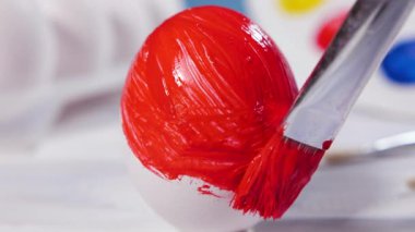 Kırmızı fırçayla Paskalya Yumurtası boyamak, bahar tatili için hazırlık dini kutlama, Sanat Renkli Kavram