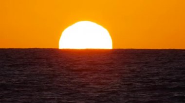 Sıcak Hava Bozukluğu 'nda Big Red Hot Sun, Okyanus Ufku' nun Üzerinde, Denizin Üzerinde Günbatımı, Bulutlu Büyük Doğan Güneş. Yakın plan Telefoto Lensleri. Seyahat, Başlangıç, Doğa Konsepti