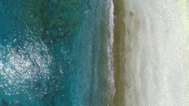Deniz üzerindeki güneşli günün havadan görüntüsü. Güzel deniz dalgaları. Beyaz kum ve inanılmaz deniz. Yaz günü deniz manzarası. Atlantik Okyanusu plajı. Su dokusu. 4K 'deki olağanüstü güneşli günün en güzel manzarası.