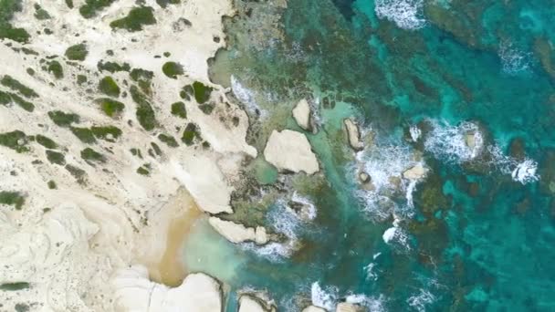 Bovenaanzicht vanuit de lucht 4k beelden door drone van oceaan blauwe golven breken op hoge klif van een rotsachtige berg. Gevaarlijke zee golven op een strand — Stockvideo