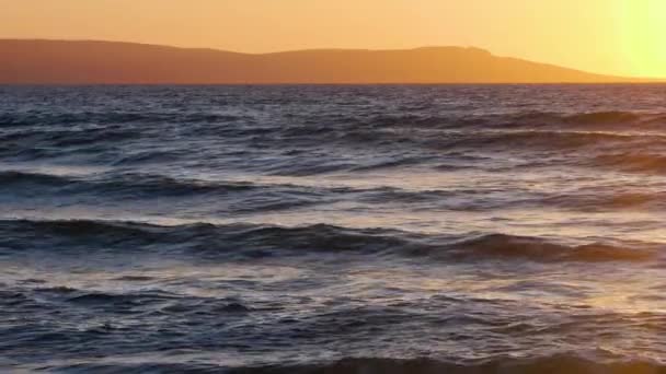 Paisaje marino dramático natural, amanecer con montañas, sol del atardecer que brilla a través de las olas doradas, océano y mar cámara lenta 4k — Vídeos de Stock