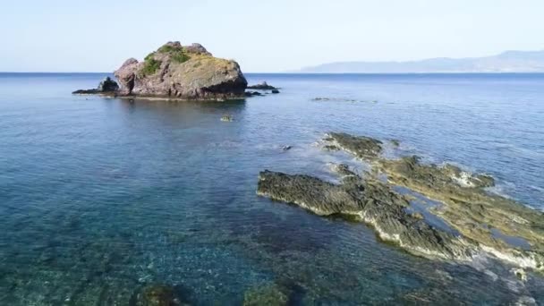 Widok z lotu ptaka na klify w błękitnym oceanie. Fale morskie na pięknej plaży dron powietrzny 4k strzał. Ocean rozbija się o Lonely Mountain Rock, Miejscowość turystyczna, wakacje i rekreacja — Wideo stockowe