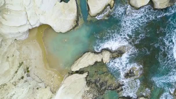 海の波は岩の背景、海の崖、キプロスの4kトップの空中ビューでビーチに対してスプラッシュ — ストック動画