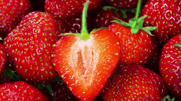 Saftige reife Erdbeeren, dekoriert mit halbierten Erdbeeren, Sommerbeeren. Das Konzept einer gesunden veganen Ernährung — Stockvideo