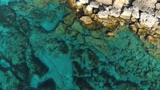 空中トップビュー海の青い水と岩の無人機による4k映像,穏やかな海は岩の山を洗います,世界のエッジと青い海のビーチ,劇的な地質学的不思議,美しい風景 — ストック動画