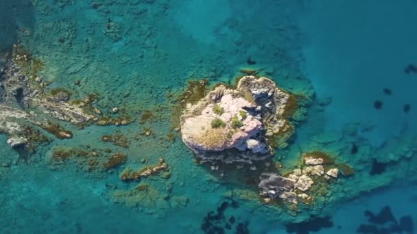 Isola e Mar Blu da una vista a volo d'uccello. Scogliera tagliente dalla pietra. Rocky reef con acqua turchese, onde dell'oceano sulla bellissima spiaggia drone vista aerea 4k, Destinazione turistica, luogo di vacanza, Cipro — Video Stock