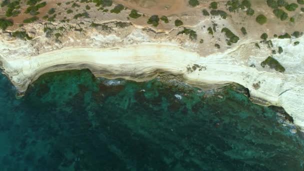 空中トップビュー海の青い水と岩の無人機による4k映像,穏やかな海は岩の山を洗います,世界のエッジと青い海のビーチ,劇的な地質学的不思議,美しい風景 — ストック動画