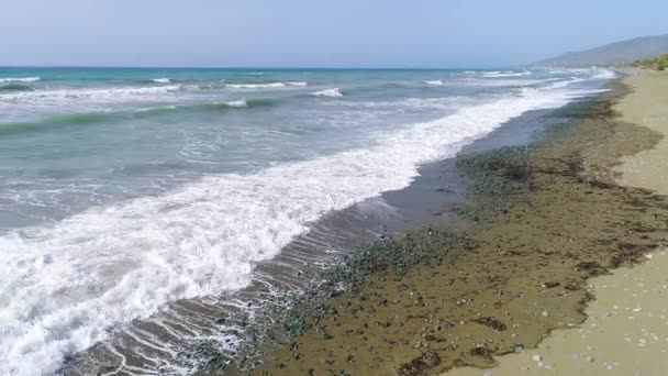 Oceánské vlny se valí shora. Vrchol dolů 4k drone pohled na modrý tyrkysový oceán, lámání vln, běloba. Slunečný den nad mořem. Obrovská vlna naráží na pobřeží. Silné vlny — Stock video