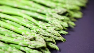 Kuşkonmaz, taze organik yeşil kuşkonmaz, yakın plan, sağlıklı vejetaryen yiyecekler. Çiğ sebze, market. Vejetaryen arka planı. Yavaş çekim 4K UHD video