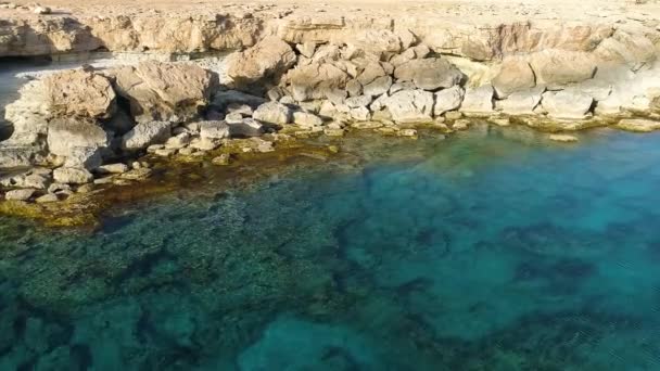 Sziklás szikla a tengerparton, Légi felvétel 4k felvétel drónnal óceán kék víz és sziklák, A világ pereme és a kék tengerpart, Drámai geológiai csoda, Gyönyörű táj — Stock videók