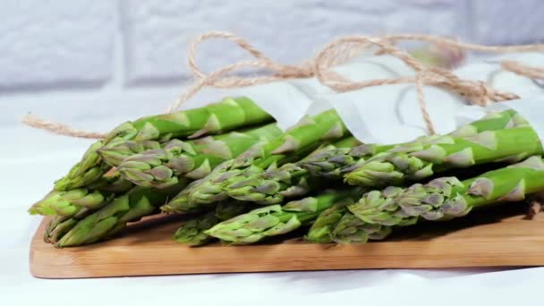 Des asperges. Choux d'asperges verts biologiques crus frais en gros plan, Alimentation végétarienne saine. Légumes crus, marché. Fond végétalien. Vidéo 4K UHD au ralenti — Video